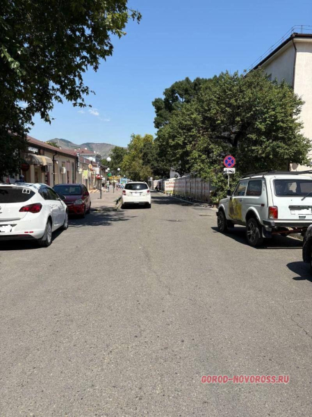 Через шлагбаум возле жилого дома охранники пропускают на парковку всех желающих за деньги
